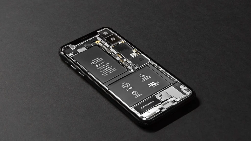 Modern smartphone resting on a dark surface with its internal hardware visible through a transparent case