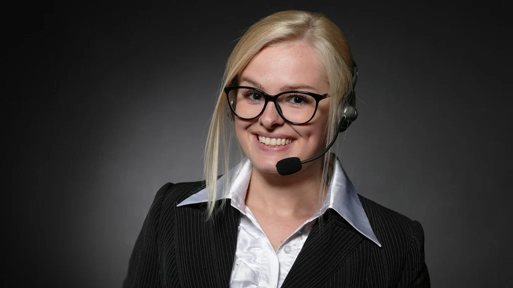 Customer support professional wearing glasses and a telephone headset