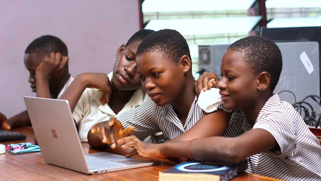 Real group of students gathered around a laptop during a learning session